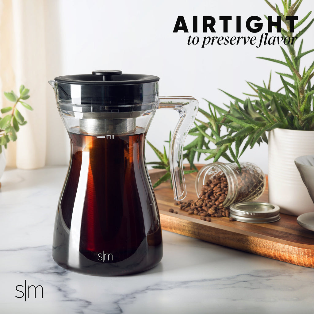 Airtight cold brew coffee maker with deep black and charcoal gray components filled with amber-brown cold brew coffee