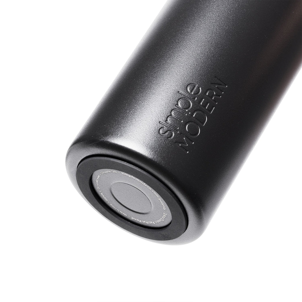 Matte black silicone drinkware with cylindrical shape and metallic base, monochromatic design with subtle gray tones