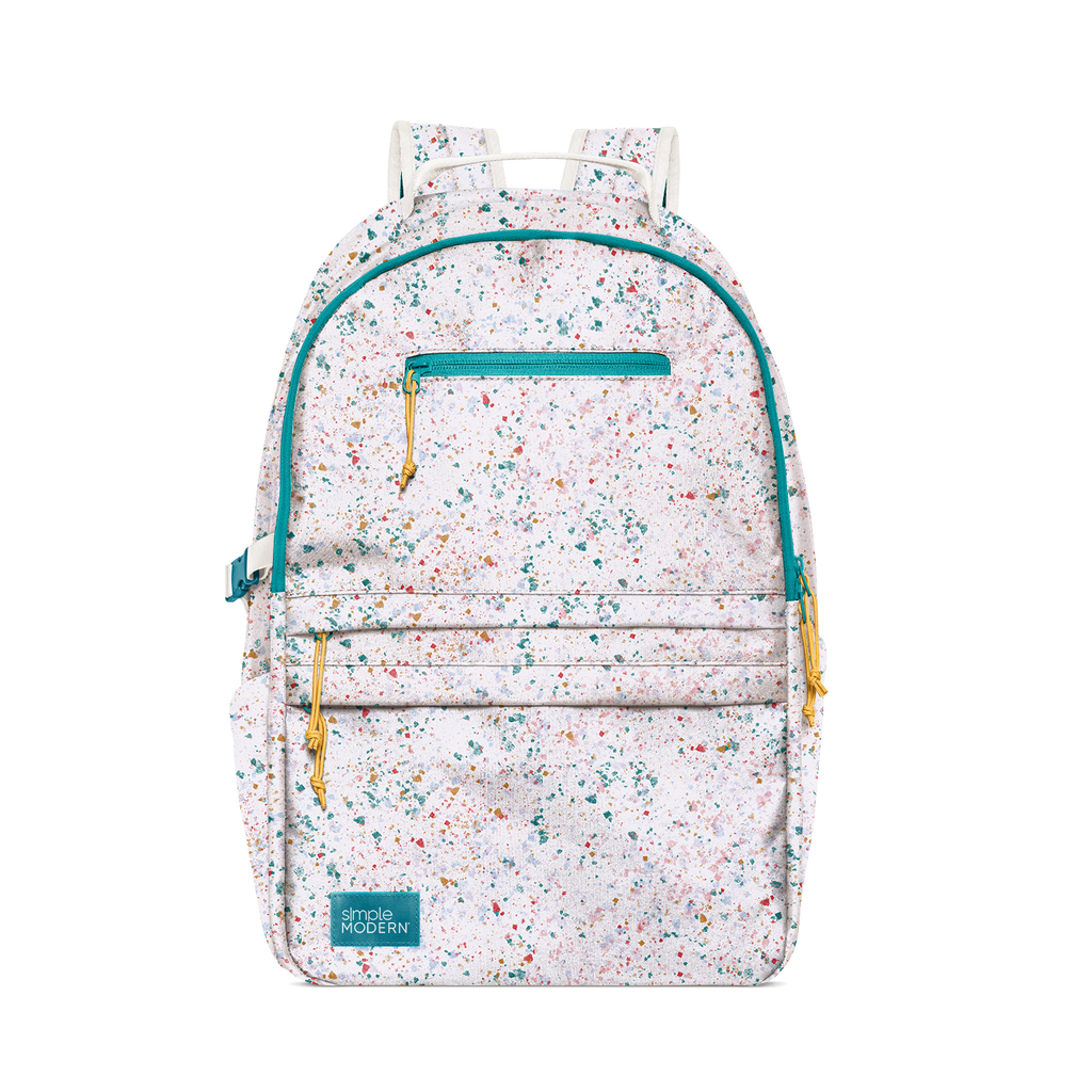 Light pink speckled backpack with teal, turquoise, coral, gold, orange, navy blue, and multicolored flecks scattered throughout the design.
