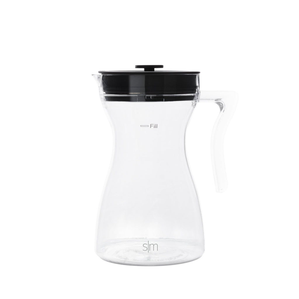 Clear glass pitcher with black handle and spout on white background