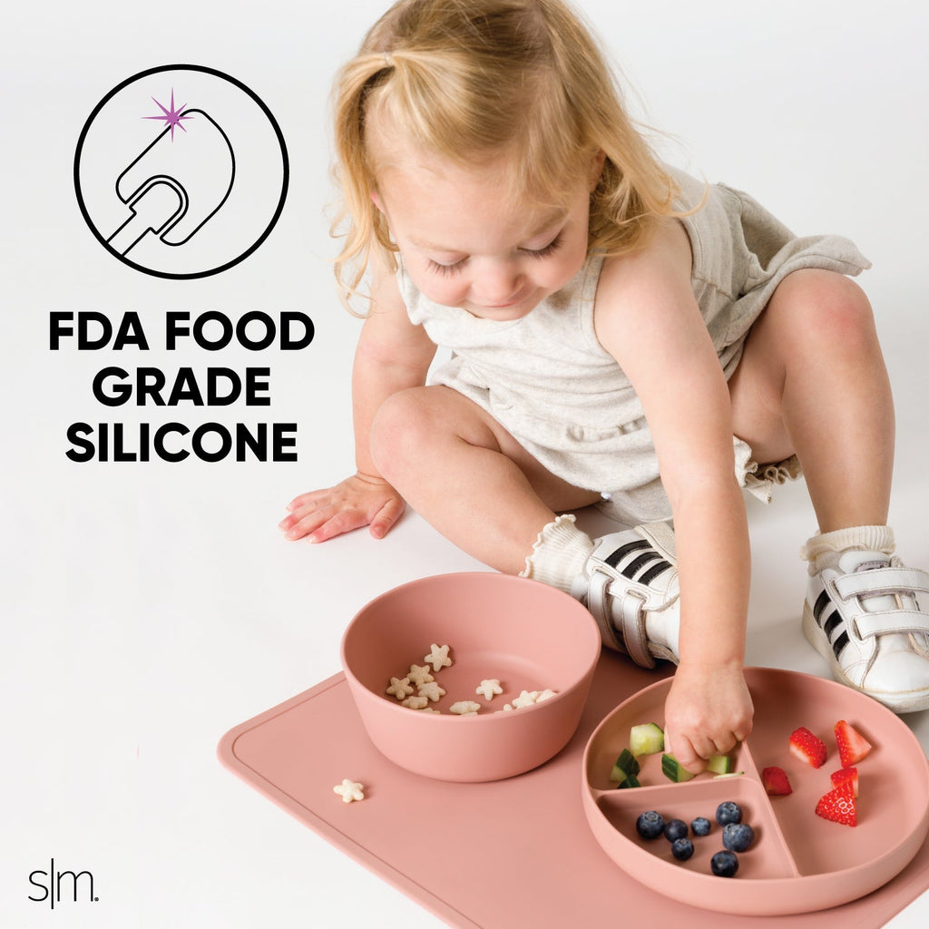 Silicone toddler dinnerware set in dusty mauve-rose pink on neutral off-white background, FDA food-grade kitchenware for babies and young children.