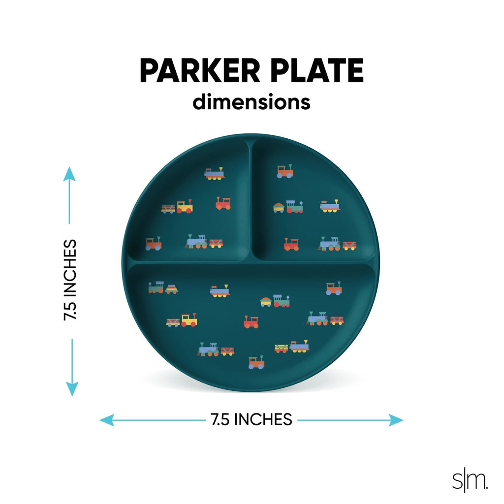 Teal silicone toddler plate with colorful train illustrations in red, orange, yellow, blue, and gray designs across the surface.